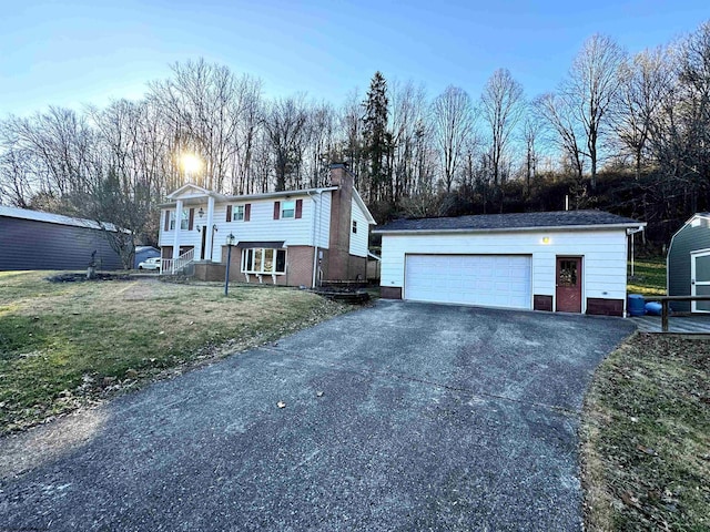 raised ranch with an outdoor structure and a front lawn