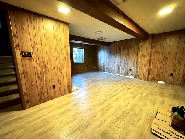 additional living space featuring wood walls, beamed ceiling, and wood-type flooring