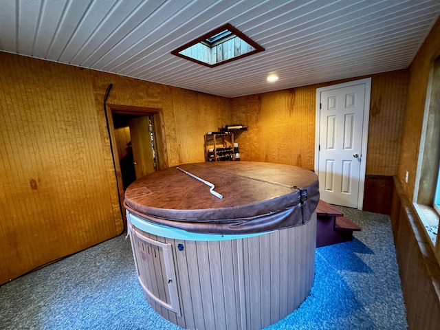 interior space with a skylight, carpet floors, and a hot tub