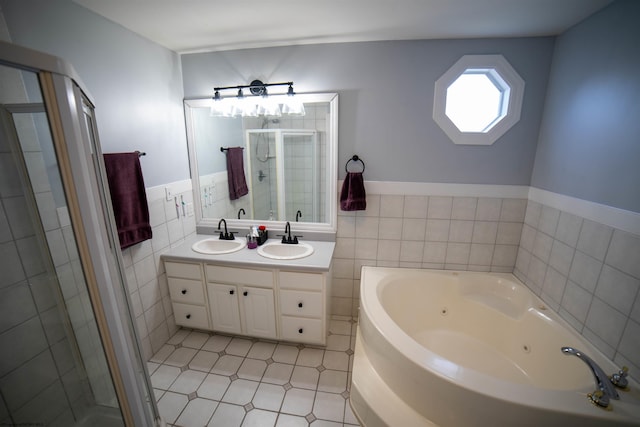 full bathroom with a shower stall, a jetted tub, tile walls, and a sink