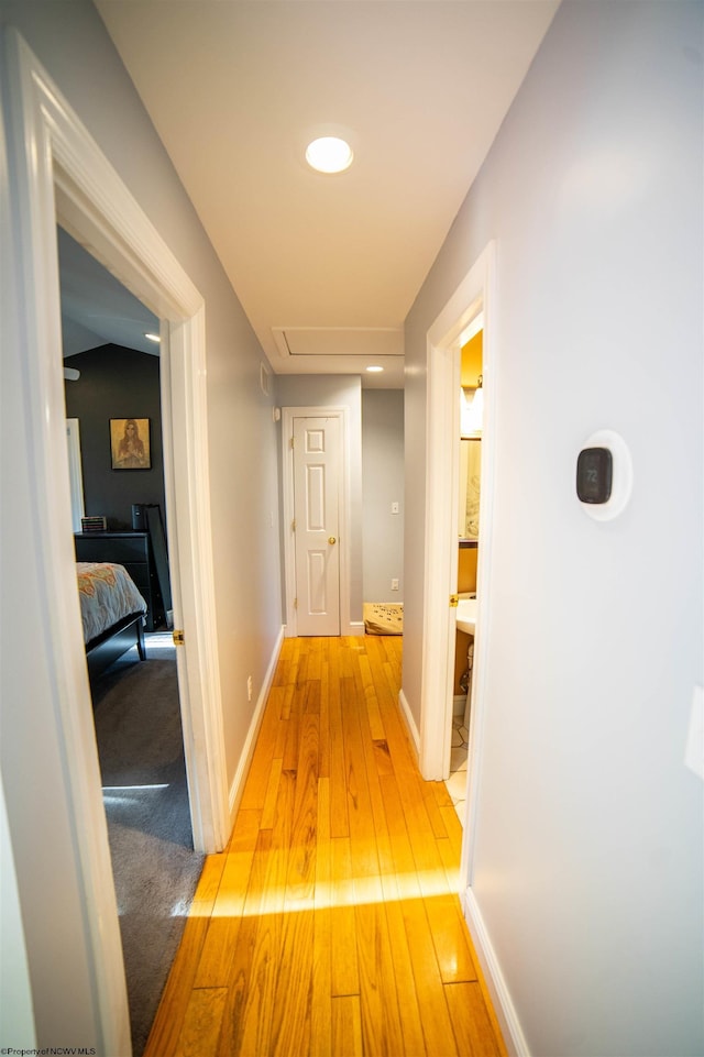 hall featuring light wood finished floors and baseboards