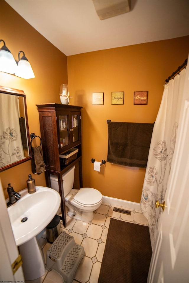 bathroom with visible vents, toilet, and baseboards