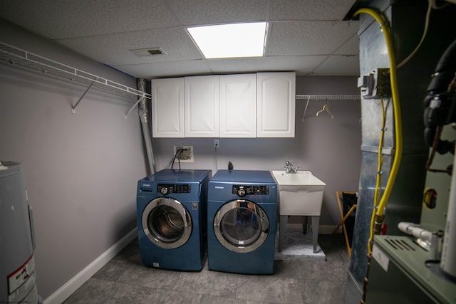 laundry area featuring visible vents, water heater, cabinet space, separate washer and dryer, and baseboards