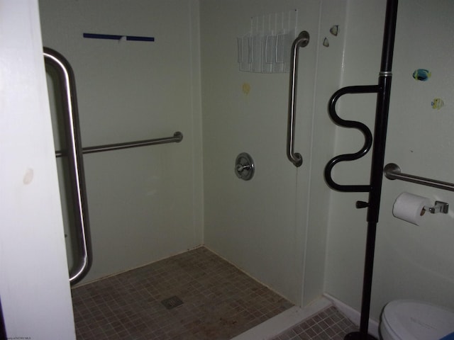 bathroom with a shower, tile patterned floors, and toilet