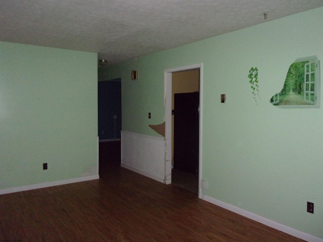 unfurnished room featuring dark hardwood / wood-style floors and a textured ceiling