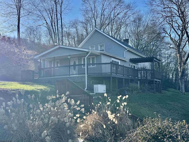 view of front of property with a wooden deck and a front lawn