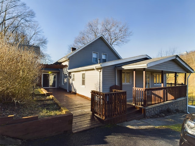 back of property featuring covered porch