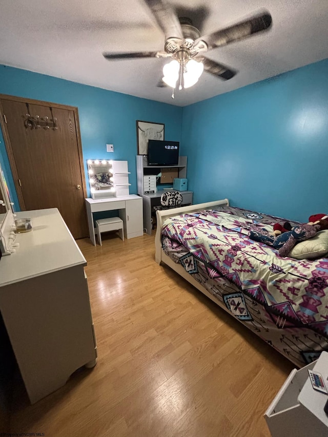 bedroom featuring a closet, a textured ceiling, light hardwood / wood-style floors, and ceiling fan