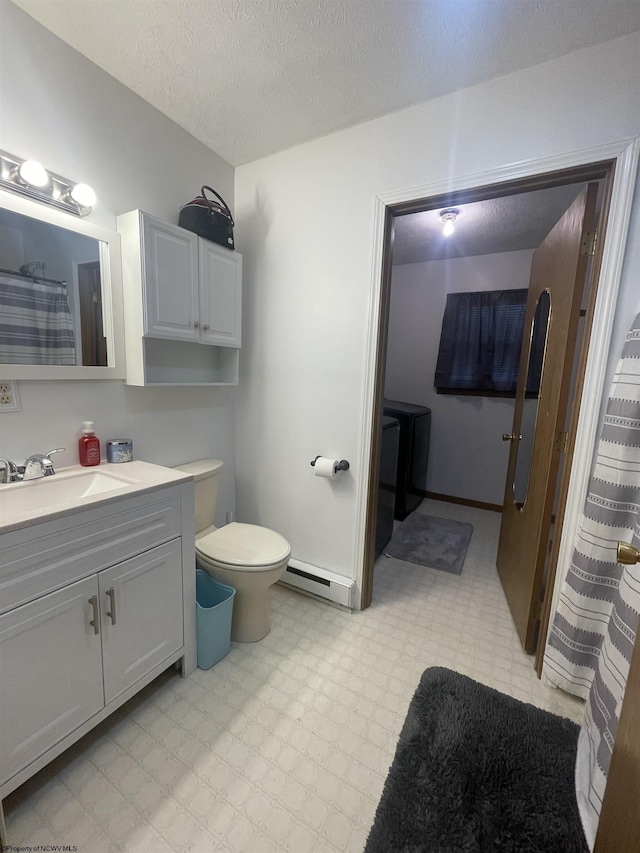 bathroom with vanity, toilet, baseboard heating, and a textured ceiling