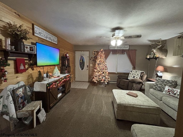 carpeted living room featuring wood walls, ceiling fan, and a textured ceiling