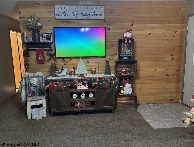 carpeted living room featuring wooden walls