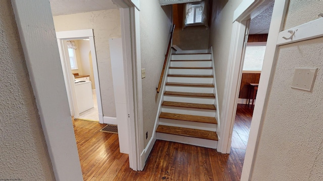 stairs with wood-type flooring and washer / clothes dryer