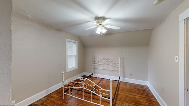 bedroom featuring ceiling fan, wood-type flooring, and vaulted ceiling