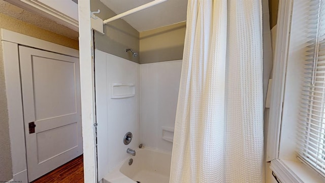 bathroom with hardwood / wood-style floors and shower / tub combo with curtain