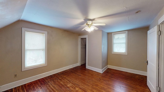 unfurnished bedroom with ceiling fan, a closet, dark hardwood / wood-style floors, and vaulted ceiling