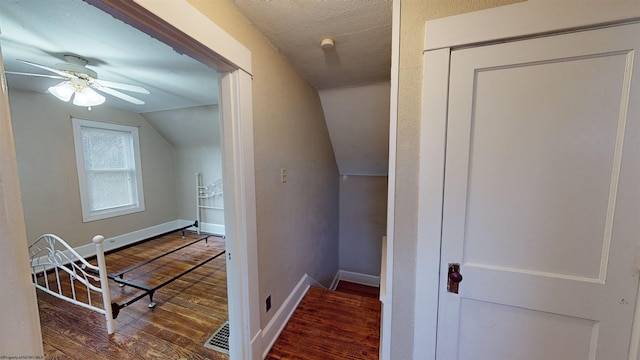 hallway with dark hardwood / wood-style floors and vaulted ceiling