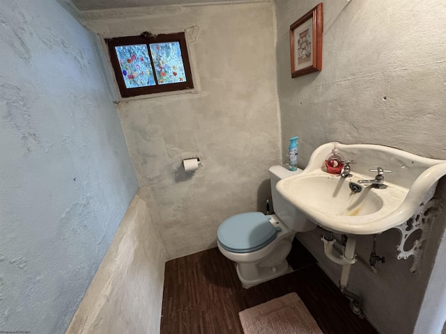 bathroom with toilet and wood-type flooring