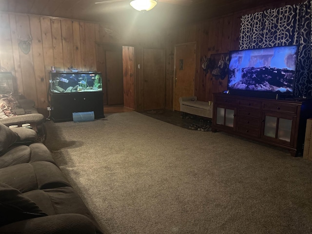 living room featuring wood walls, carpet floors, and ceiling fan