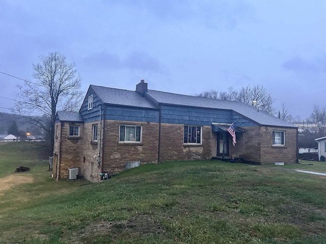 view of front of property with central AC, a front lawn, and a chimney