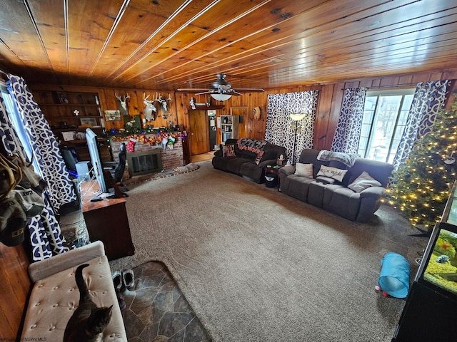 living area featuring a fireplace, wood walls, wooden ceiling, and carpet flooring