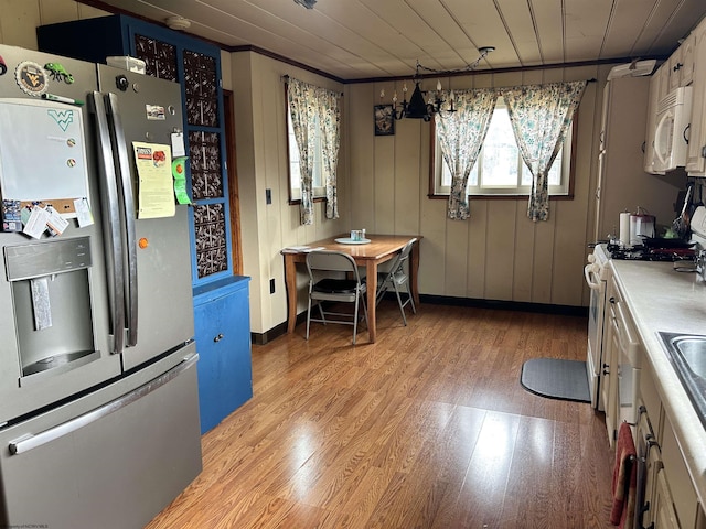 kitchen with light wood-style floors, wood ceiling, white appliances, and light countertops