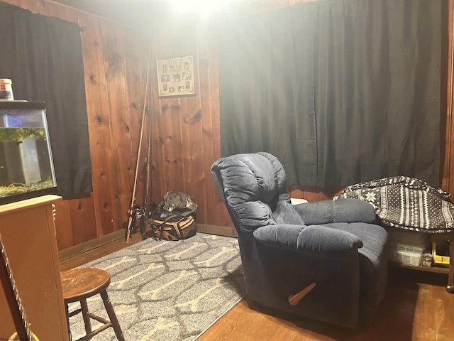 sitting room with wood-type flooring and wooden walls