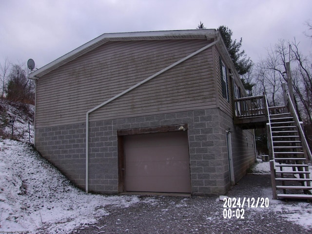 view of snowy exterior featuring a garage