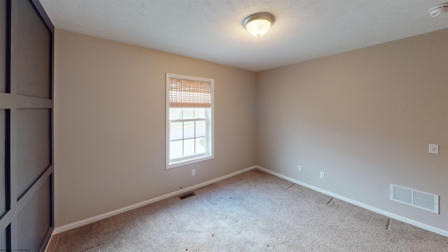 unfurnished bedroom featuring a textured ceiling and light carpet