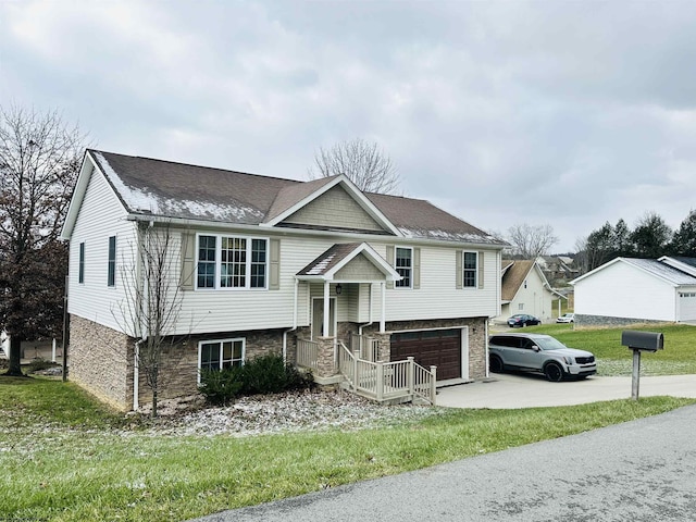 raised ranch featuring a front yard and a garage