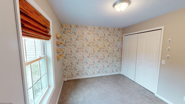 unfurnished bedroom with light carpet and a closet