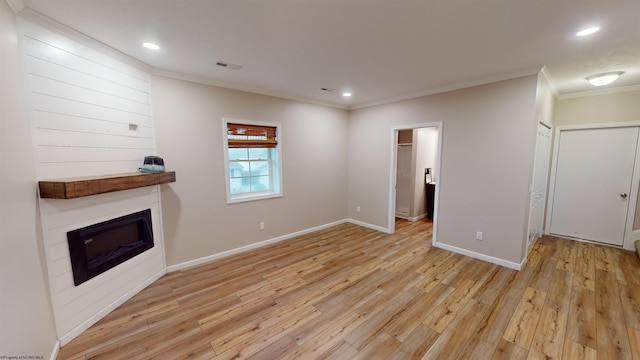 unfurnished living room featuring light hardwood / wood-style flooring and ornamental molding