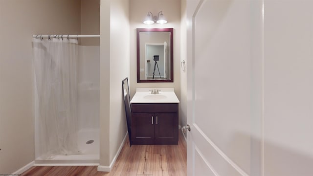 bathroom with vanity, wood-type flooring, and walk in shower