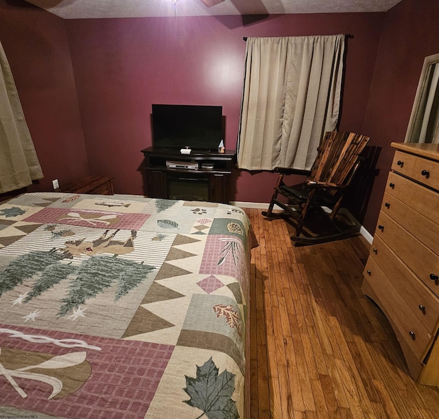 bedroom with a textured ceiling and hardwood / wood-style flooring