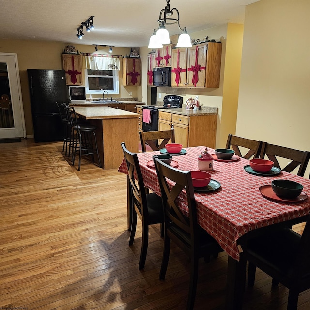 dining space with light hardwood / wood-style flooring and sink