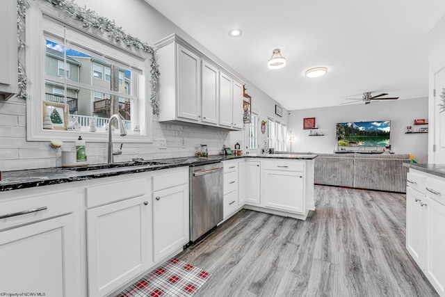 kitchen with ceiling fan, stainless steel dishwasher, kitchen peninsula, decorative backsplash, and white cabinets