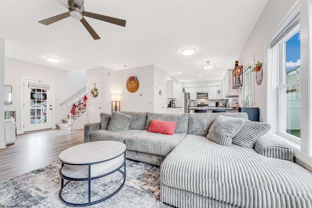 living room featuring a wealth of natural light, sink, ceiling fan, and light hardwood / wood-style floors