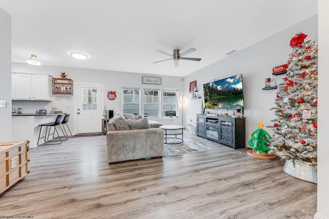 living room featuring ceiling fan and light hardwood / wood-style flooring