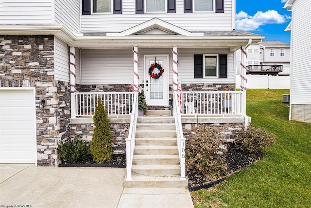 property entrance with covered porch, a yard, and a garage