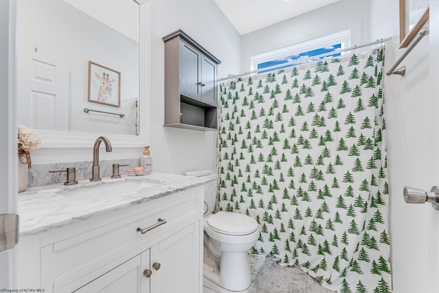 bathroom with curtained shower, vanity, and toilet