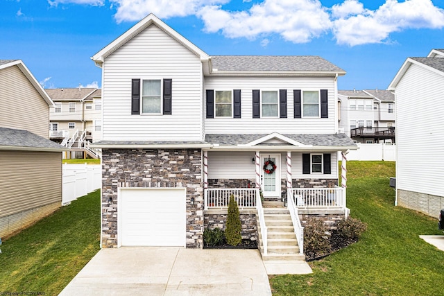 view of front of property featuring a garage, covered porch, and a front yard