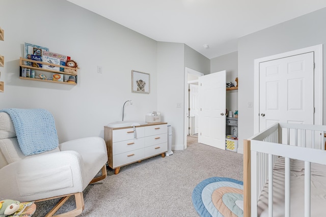 bedroom featuring light carpet and a crib