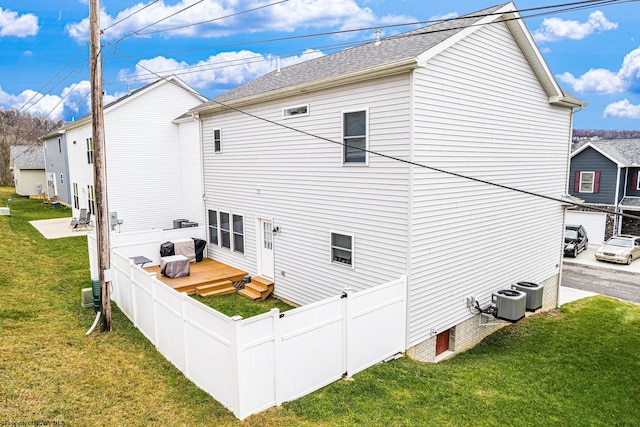 back of property with cooling unit, a deck, and a yard