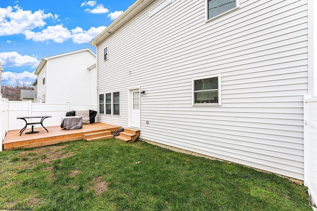 rear view of property with a lawn and a wooden deck