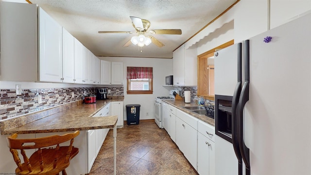 kitchen featuring ceiling fan, sink, a textured ceiling, white appliances, and white cabinets