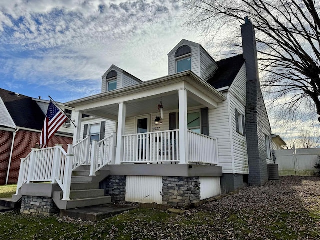 bungalow-style home with a porch and central air condition unit