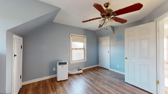 additional living space with ceiling fan, light wood-type flooring, and vaulted ceiling