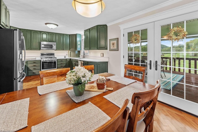 kitchen with french doors, green cabinets, sink, ornamental molding, and stainless steel appliances