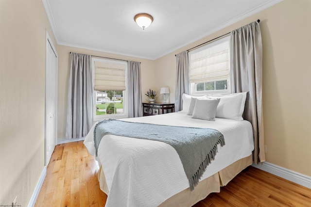 bedroom with multiple windows, ornamental molding, and hardwood / wood-style flooring