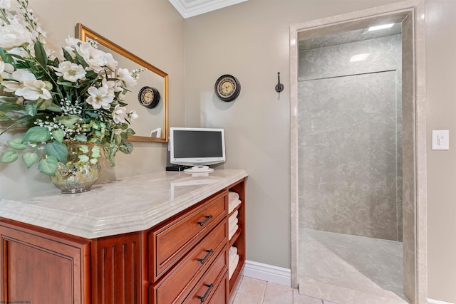 bathroom with tile patterned flooring, vanity, ornamental molding, and walk in shower