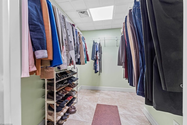 walk in closet with light tile patterned floors